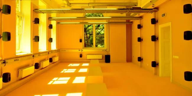 Yellow enlighed room with loudspeakers. Photo.